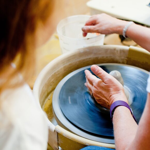 Person making pottery on a wheel
