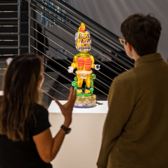 Two people discussing a glass deity in ICA an Diego / Central gallery space