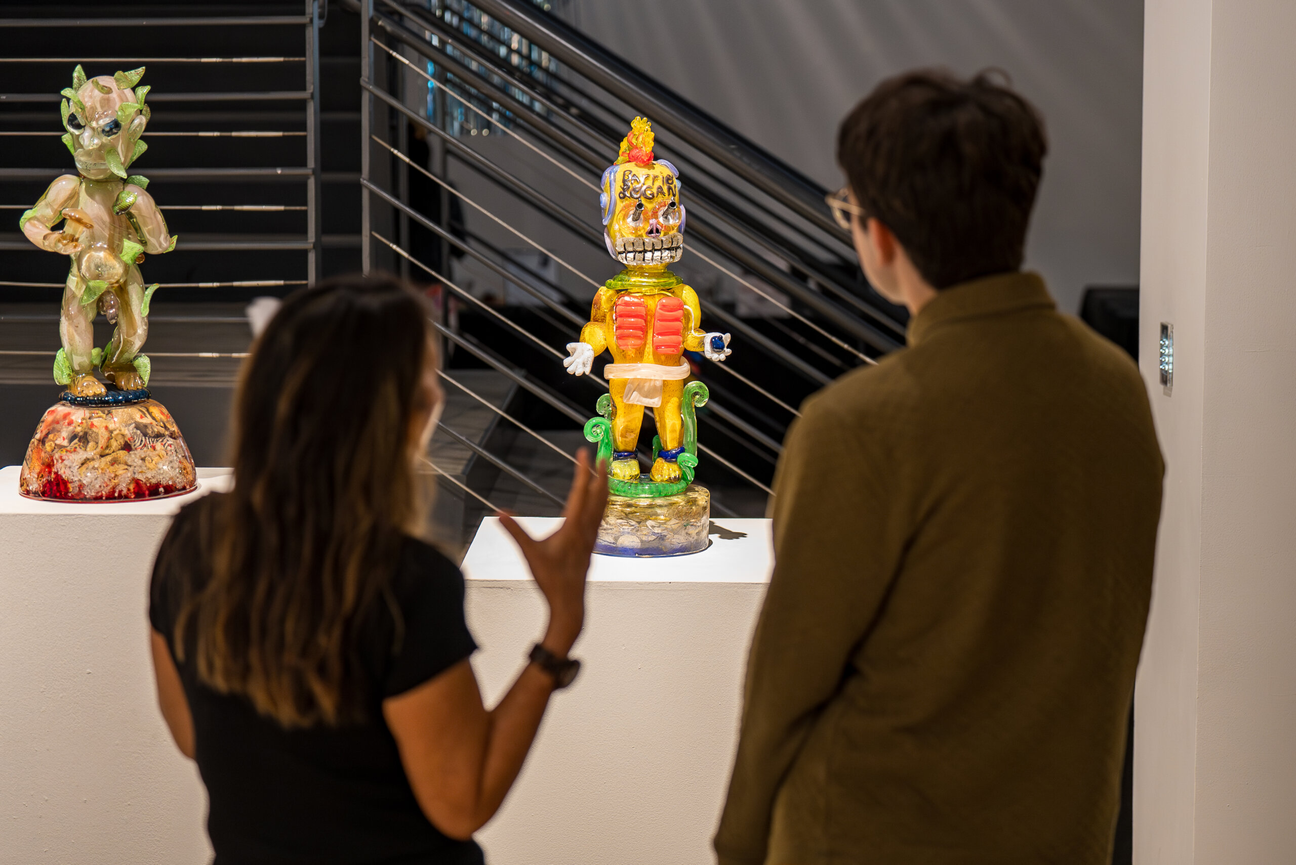 Two people discussing a glass deity in ICA an Diego / Central gallery space